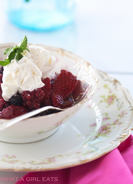 Cooked summer berries with fresh whipped cream.