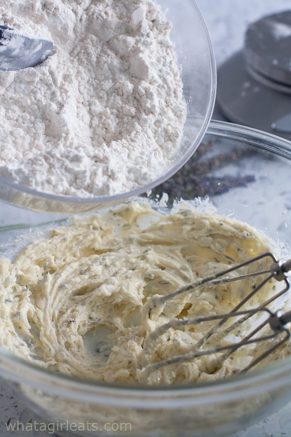 adding flour to shortbread dough