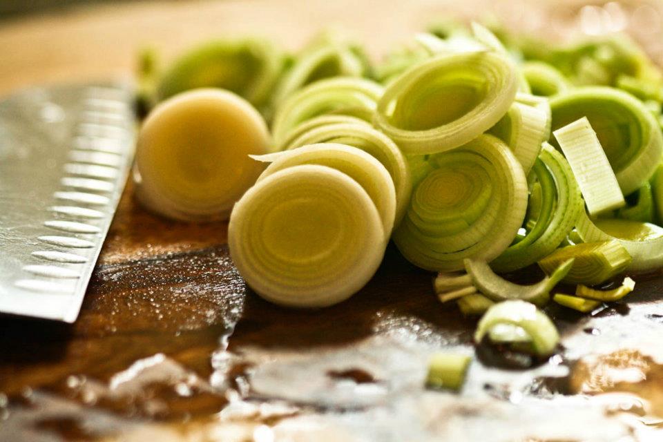 Closeup of sliced leeks on a cutting board.