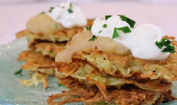 Potato pancakes topped with sour cream and applesauce.