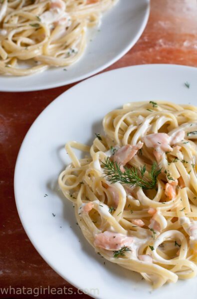 pasta with smoked salmon and dill on pink background.