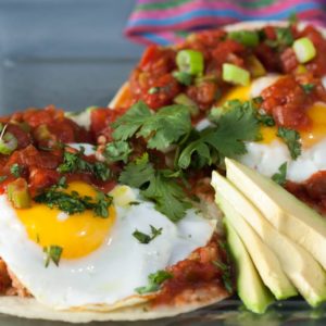 Huevos Rancheros is a popular Mexican dish of fried or poached eggs served on a tortilla with a spicy tomato sauce. Here's the recipe to make them at home! | What a Girl Eats