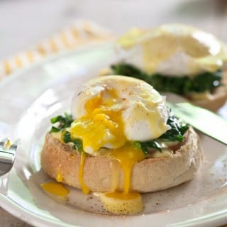 Eggs Florentine, poached eggs on a bed of spinach and canadian bacon topped with easy blender hollandaise sauce.
