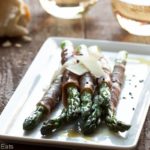Prosciutto wrapped asparagus is a delicious, easy to make appetizer or side dish recipe. Tender spring asparagus is wrapped with salty prosciutto and shaved Parmesan cheese. | WhatAGirlEats.com