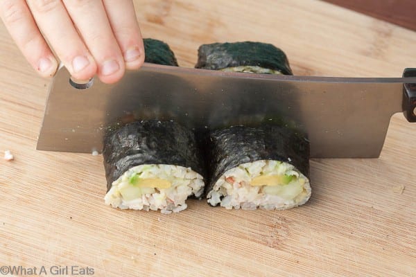 Cutting the California Roll into bite-sized pieces.