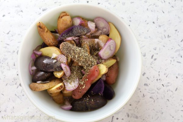tossing fingerling potatoes with herbes.