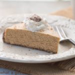 Gluten-free pumpkin spice cheesecake with Bourbon Maple whipped cream and sugared pecans. A delicious fall dessert recipe. | WhatAGirlEats.com