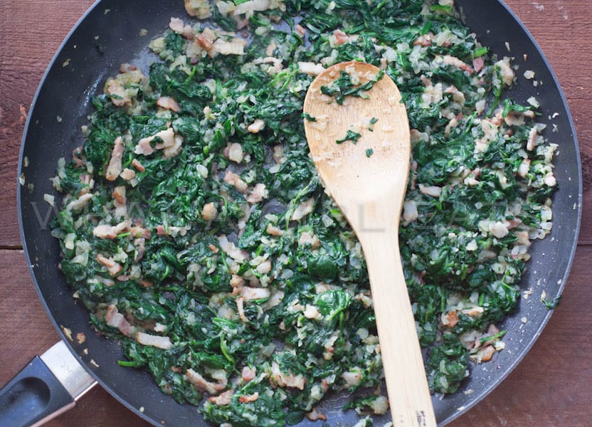 Spinach, onions and bacon in a pan.