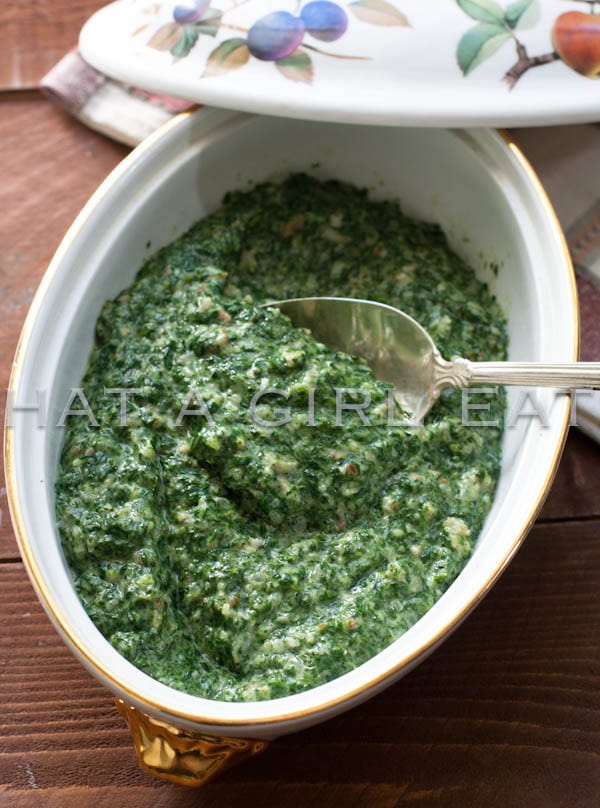 Creamed spinach in a serving dish with a spoon.