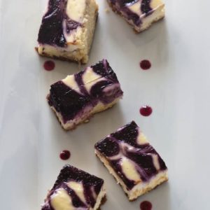 Lemon Cheesecake Blueberry Swirl Bars are a rich, creamy lemon cheesecake bars with swirls of fresh blueberry sauce throughout. | WhatAGirlEats.com
