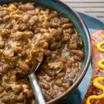 Boston baked beans are a must-have side dish for picnics and potluck dinners. This easy-to-make slow cooker Boston baked beans recipe helps you make them in a snap! | WhatAGirlEats.com