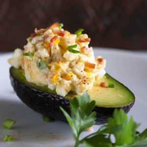 Egg salad with bacon is a delicious spin on a traditional egg salad recipe. Creamy egg salad and crisp bacon, combined and served in fresh avocado halves. | @whatagirleats