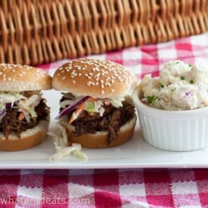 Slow Cooker Pulled Pork Sliders - the perfect game day food, topped with homemade barbecue sauce! Recipe from What a Girl Eats.
