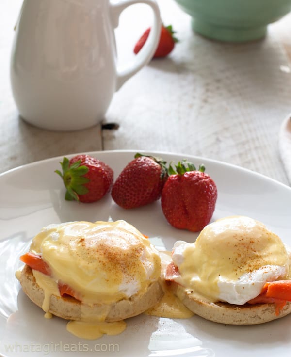 Eggs Royale on a white plate with fresh strawberries. 