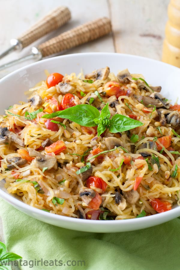 Tomato Mushroom Spaghetti Squash Pasta with tomatoes and mushrooms, topped with basil leaves.