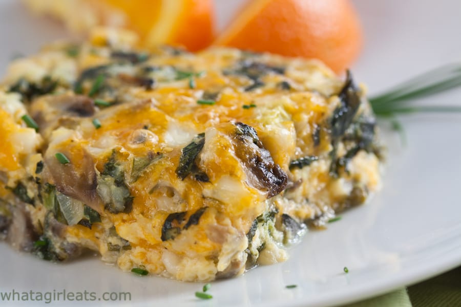 Cheesy spinach and mushroom breakfast casserole on a plate.