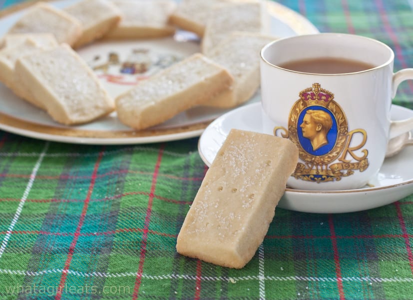 Scottish shortbread cookies on a plate next to a cup of tea.