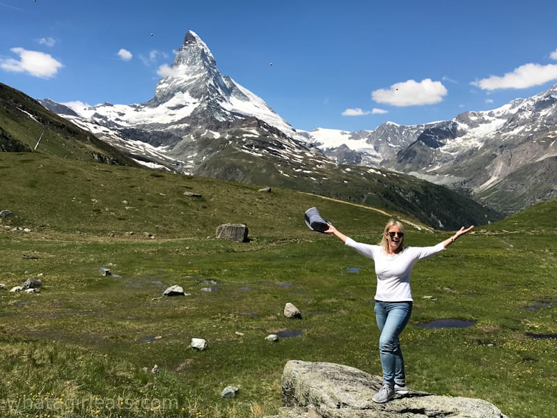 Smiling woman holding her arms out with Matterhorn in background.