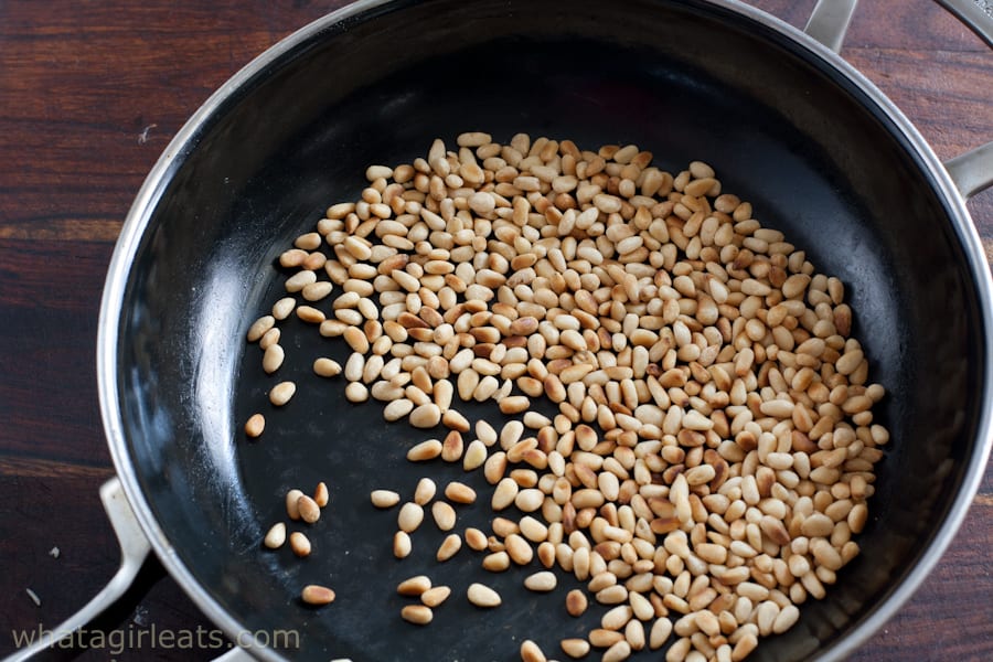 Toasted pine nuts in a frying pan.