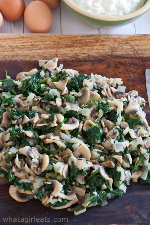 Spinach and mushrooms chopped up on a cutting board