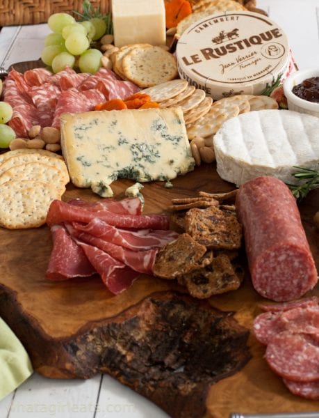 Meats, cheeses and crackers on a charcuterie board.