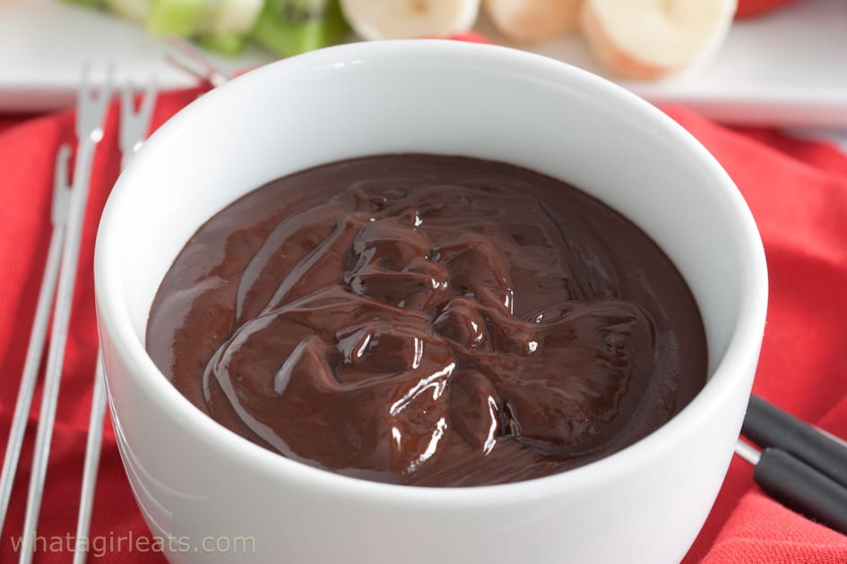Chocolate fondue in a white pot.