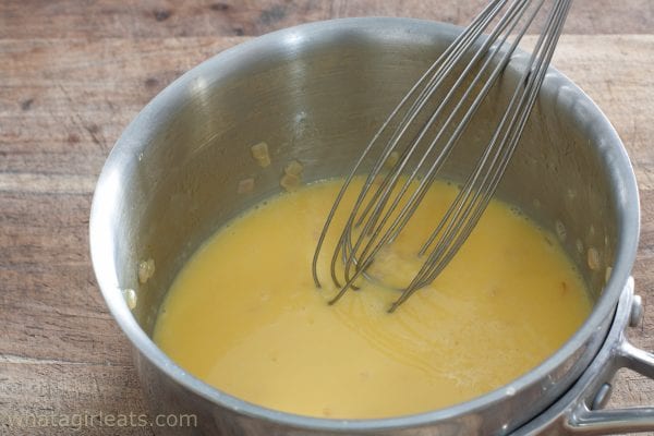 Whisking saffron beurre blanc in a saucepan.