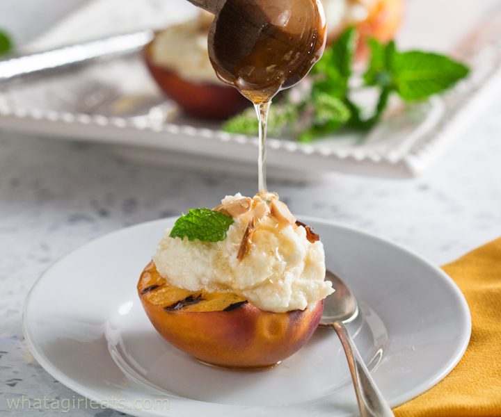 Honey being drizzled on a grilled peach with mascarpone.