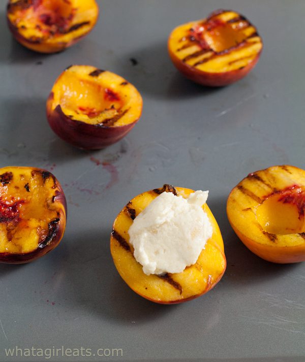 Grilled peaches being filled with mascarpone.