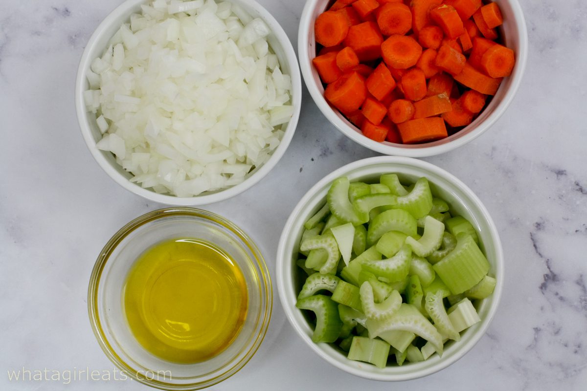 carrots, onions and celery in glass bowls.