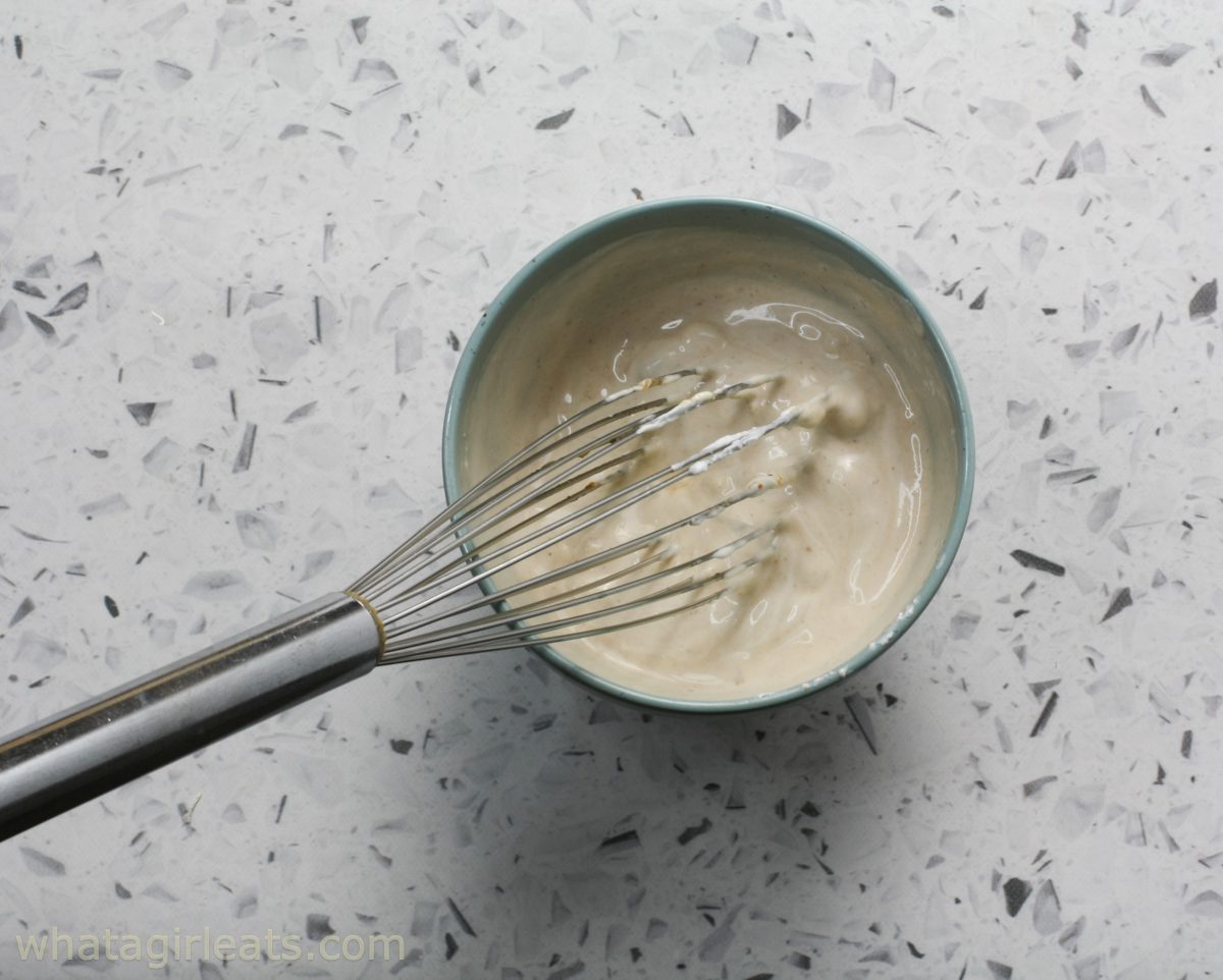 Adding sour cream to stroganoff.