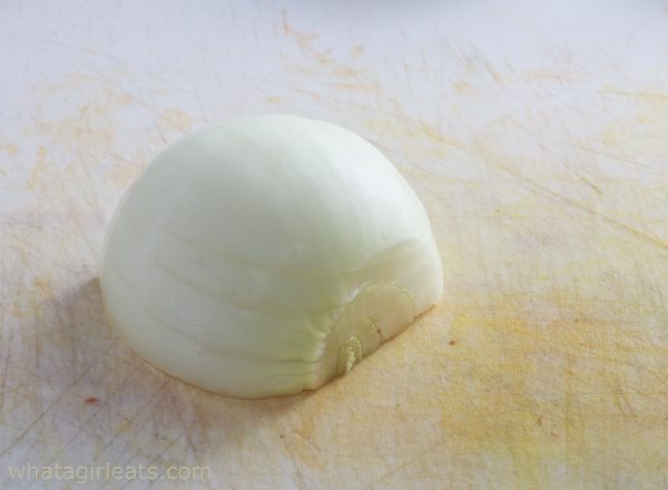 half of an onion on a cutting board.