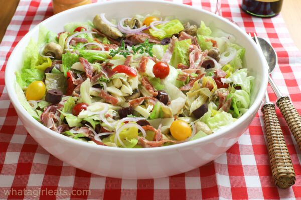 Italian sub salad on red checked cloth.