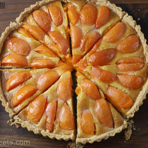 Apricot tart with slice and serving utensil.