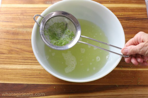 straining lime juice.
