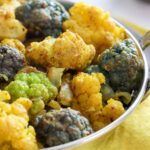 curried cauliflower in metal dish.