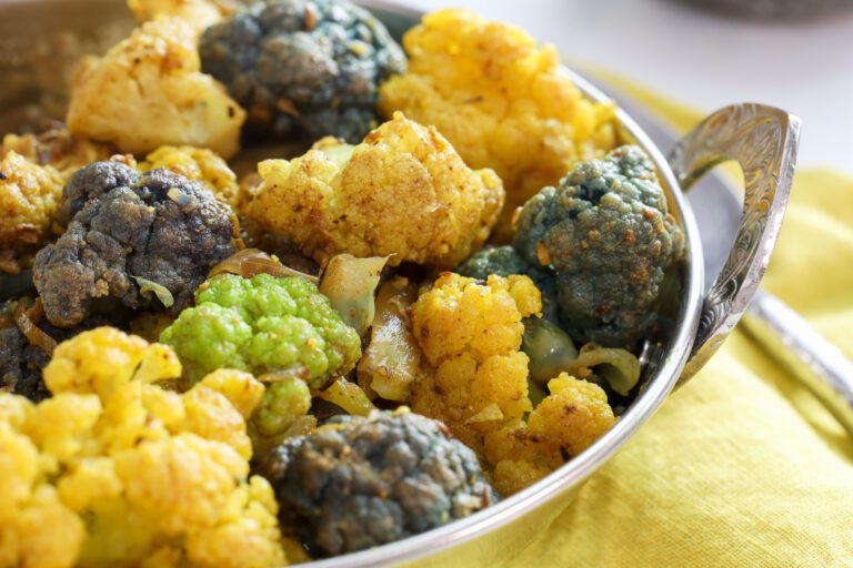 curried cauliflower in metal dish.
