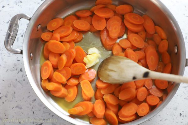 adding butter to carrots.