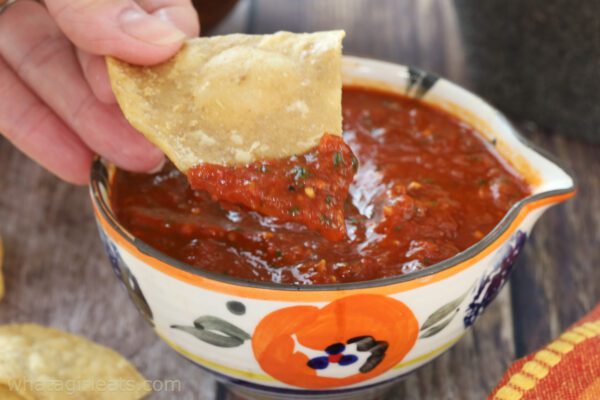dipping chip in salsa roja.