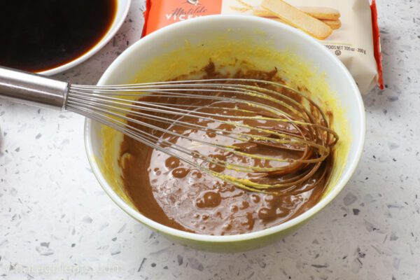 adding melting chocolate to egg yolks adding chocolate to mascarpone.