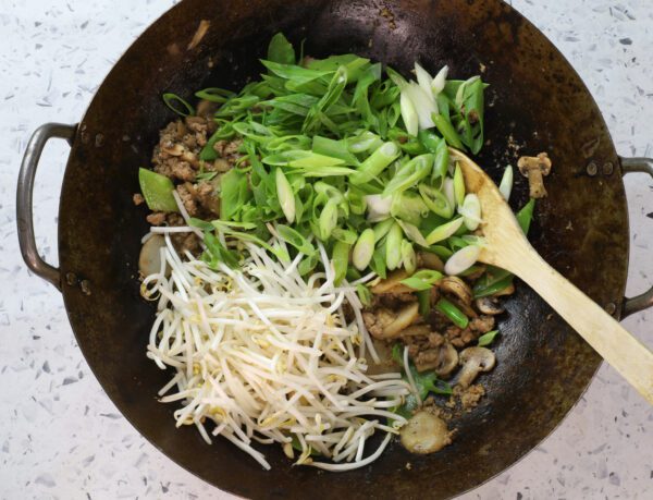 adding bean sprouts and green onions.