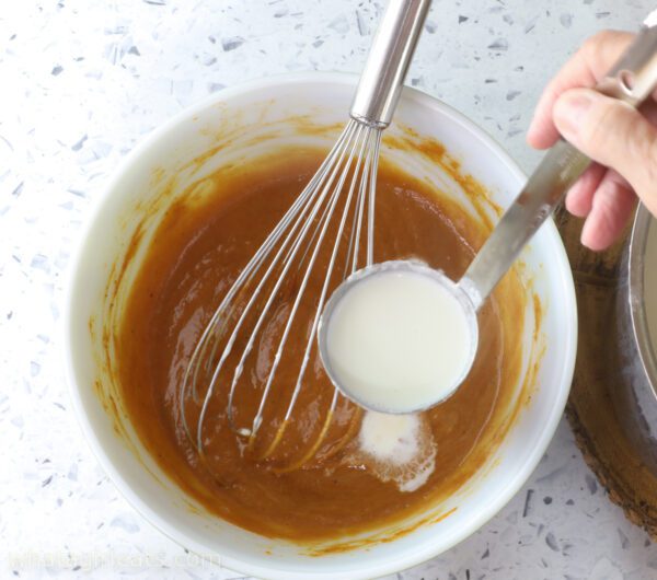 adding ladleful on cream into pumpkin adding cream to pumpkin mixture.