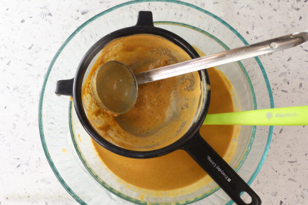 straining pumpkin ice cream base straining ice cream base.